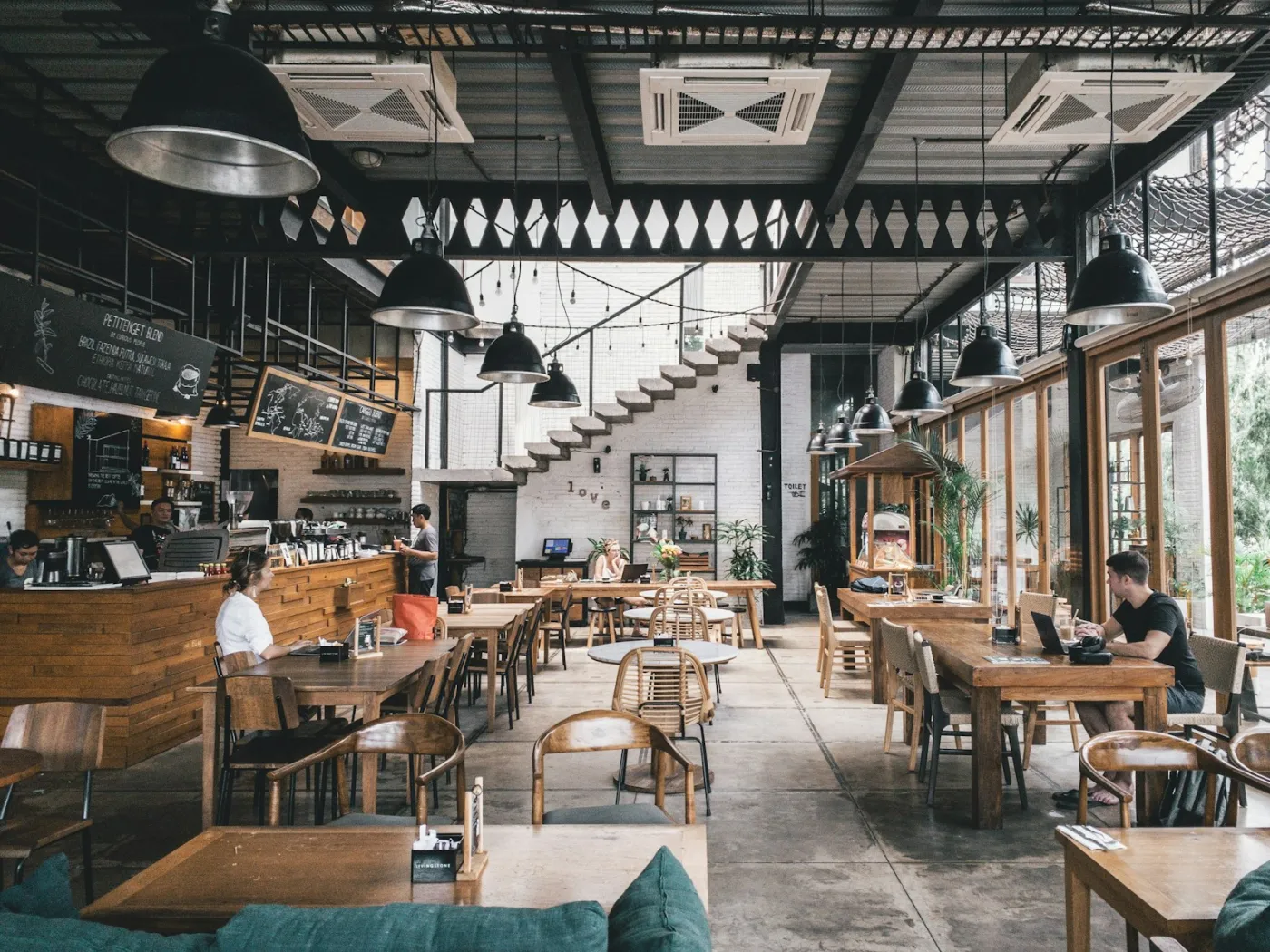 The dining room of a light-filled café with timber tables